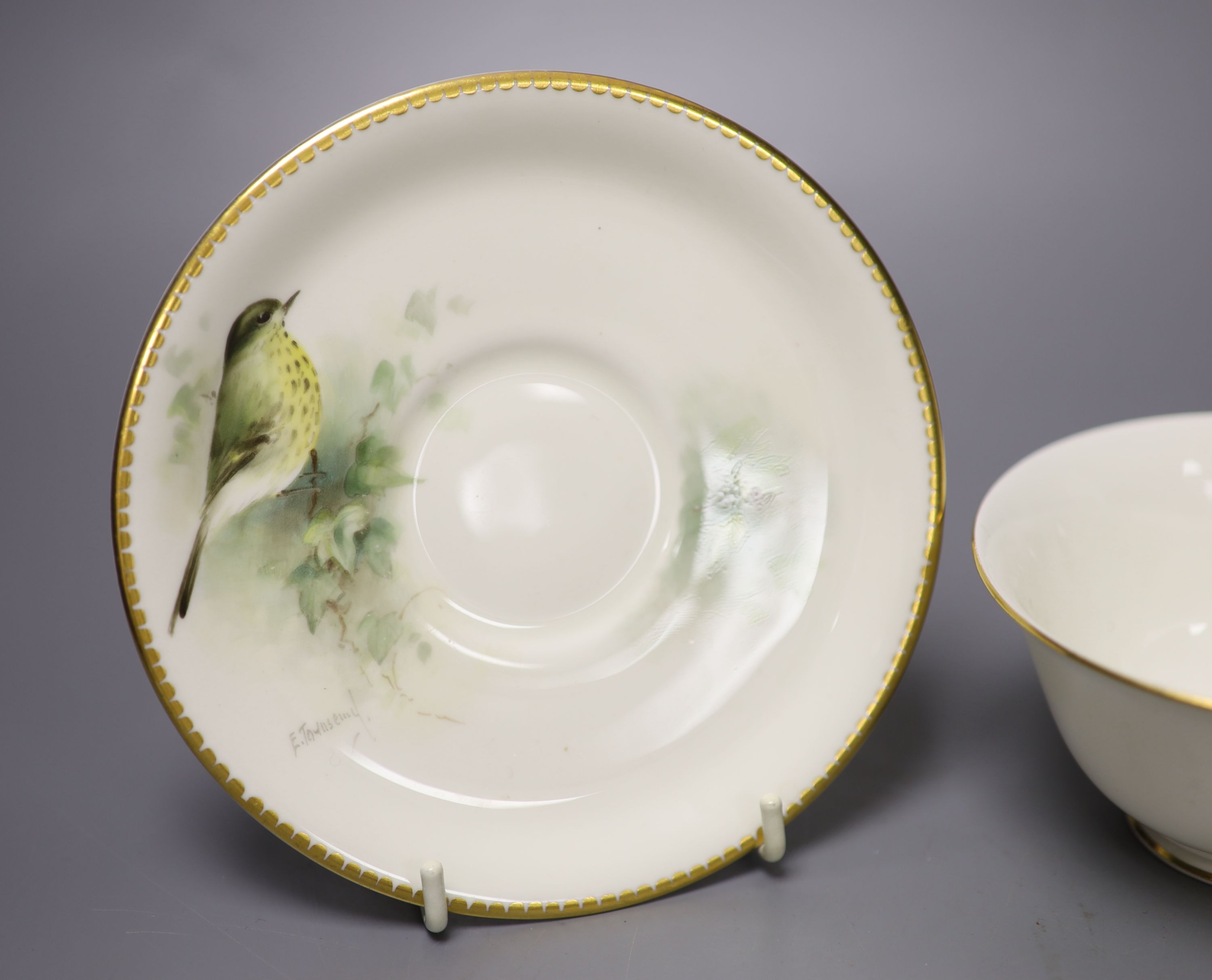 A Royal Worcester teacup, saucer and side plate, each unusually painted with a thrush on a branch by E. Townsend, signed black mark,